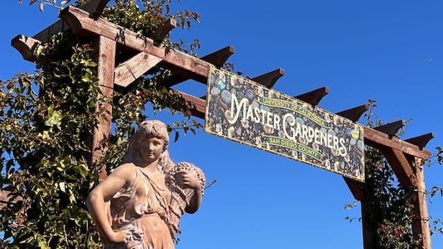 Sign and Woman Statue at the entrance to the Master Gardeners Demonstration Garden at the Carlsbad Flower Fields