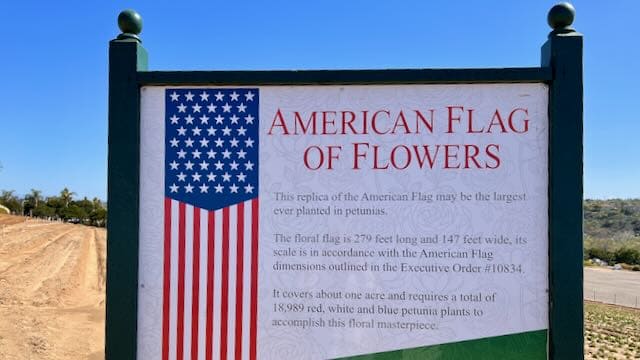 Sign for the American flag of flowers with no Flowers blooming behind it in early March at the Carlsbad Flower Fields